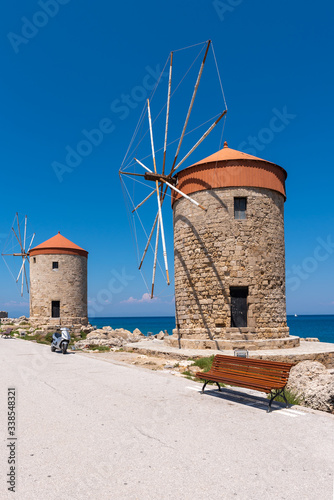 Windmills and the fort of St. Nicholas in the port of Mandraki in Rhodes. Greece