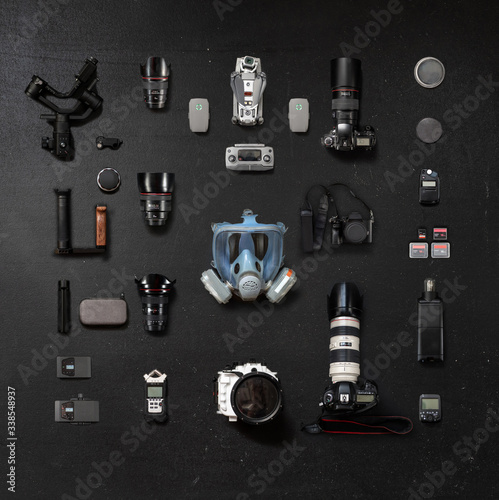 Protective mask and a collection of lenses and photo cameras on a black background
