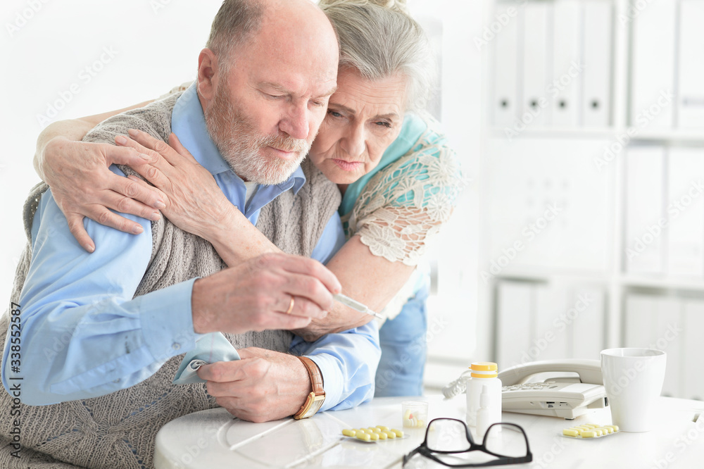 Portrait of ill senior couple with thermometer at home Portrait of ill senior couple with thermometer at home