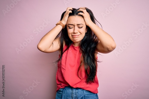 Foto Young brunette woman wearing casual summer shirt over pink isolated background suffering from headache desperate and stressed because pain and migraine