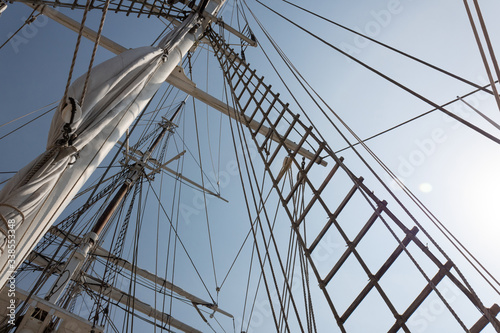Tall ship rigging and shroud, masts and ropes against a blue sky, horizontal aspect