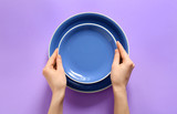 Woman at table with clean plates, top view