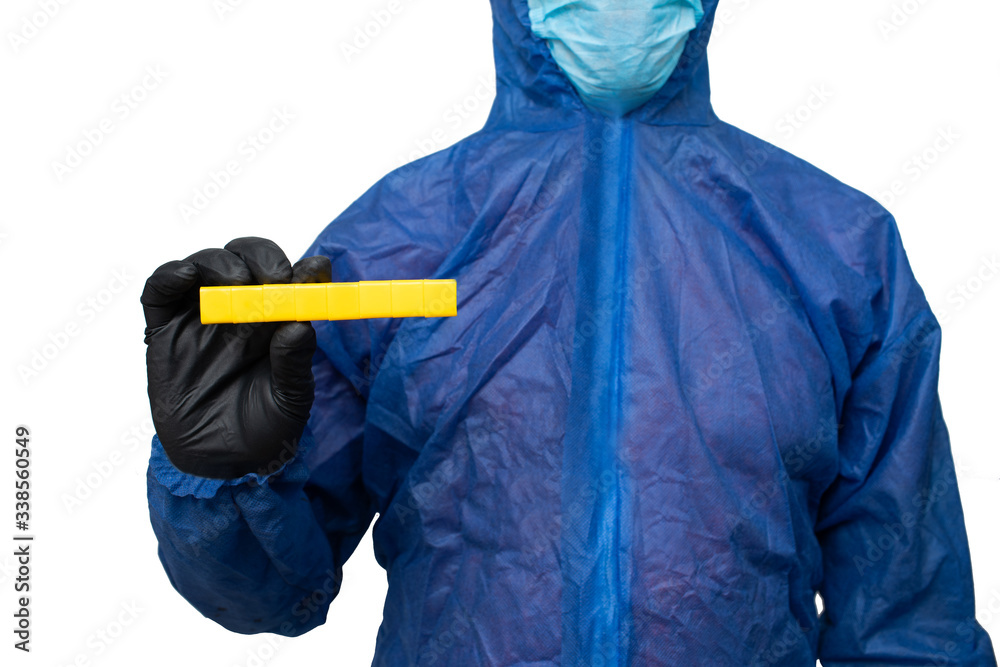 a man in a protective blue suit and mask holds a sign