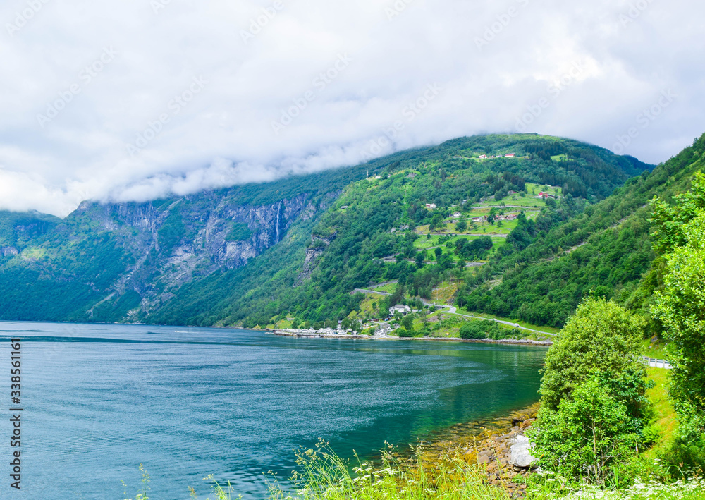 Fototapeta premium Landscape of the serpentine Eagles Road, rising along the slope of the mountain above the Geirangerfjord near the village of Geiranger.