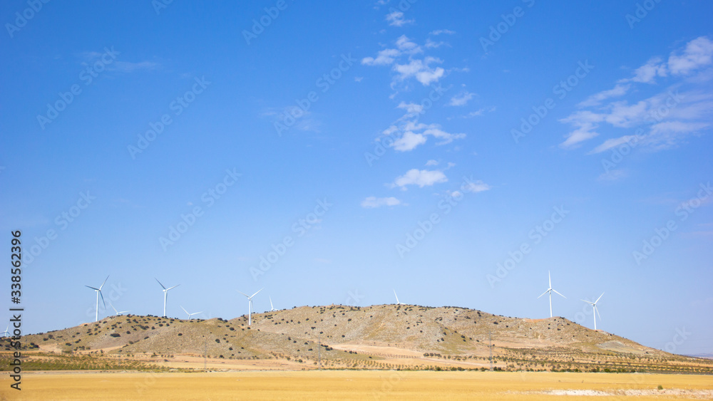 Landscape with wind turbine moving its blades generating alternative renewable energy for the environment