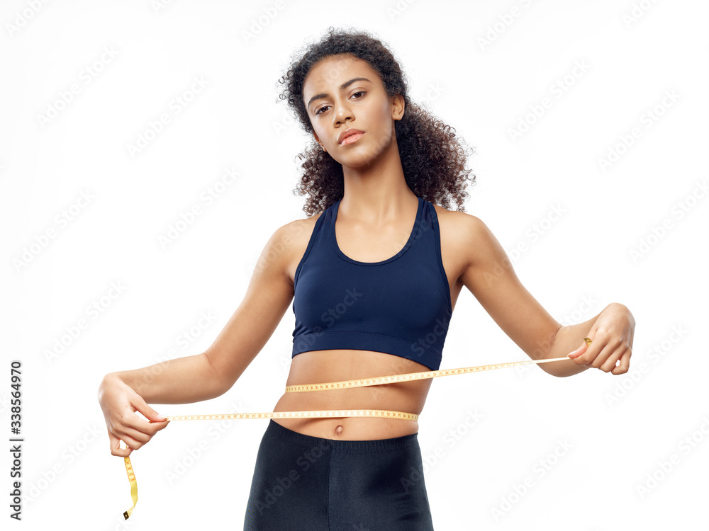 young woman measuring her waist young woman measuring her waist