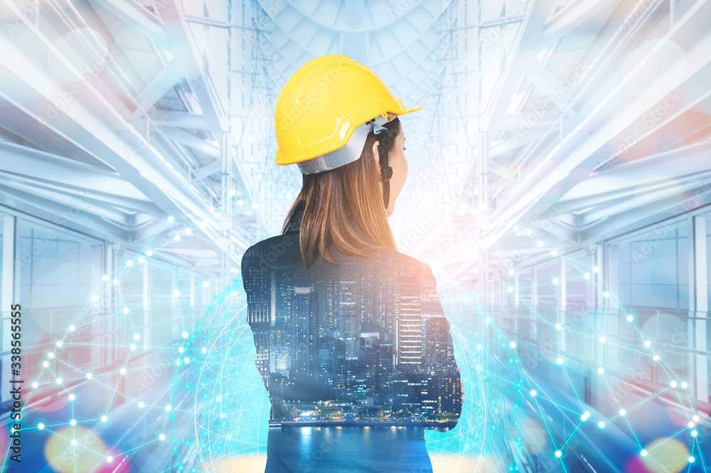 Double exposure of the Business woman in engineering standing against build structure and futuristic world. Concept of engineering, construction, smart city and communication.