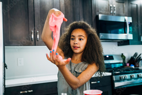 Girl making homemade slime in home kitchen
