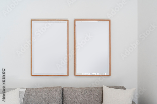 Interior decoration, empty wooden vertical frames, poster white canvas mock up on a white wall, living room template front view