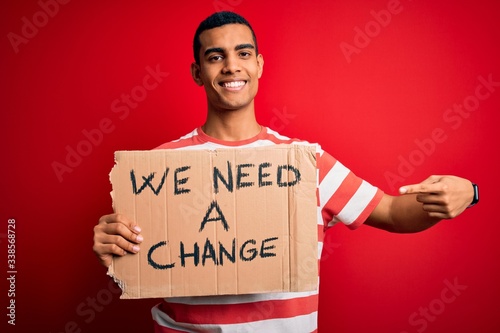 Young handsome african american activist man asking for change holding banner wi Fototapet