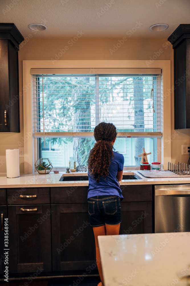 Girl washing dishes at kitchen sink Girl washing dishes at kitchen sink