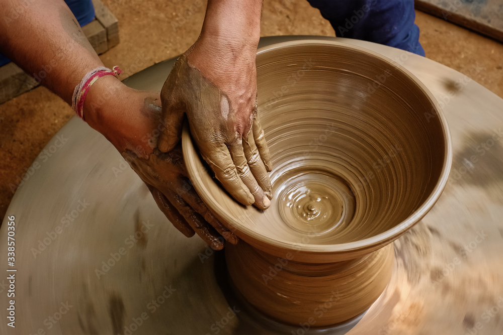 Φωτογραφία Pottery - skilled wet hands of potter shaping the clay on potter wheel