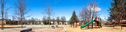 Empty school playground on a sunny Saturday. Police tape wrapped around playground, preventing kids from using slides, climbing net an swing set. COVID-19 Pandemic. Eastern 2020, East Vancouver.