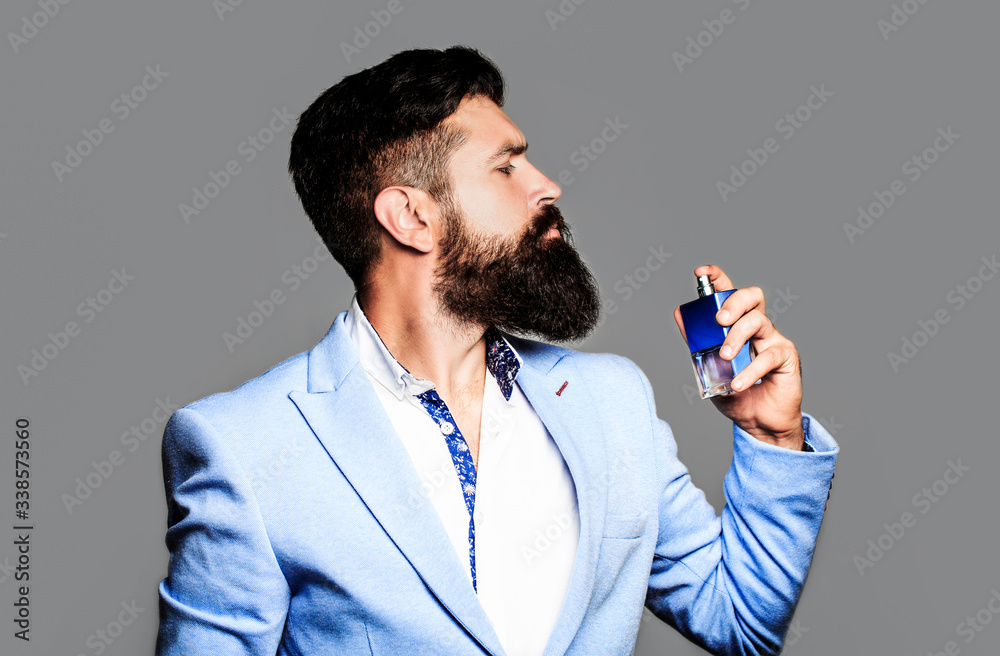 Perfume or cologne bottle, perfumery, cosmetics, scent cologne bottle, male  holding cologne. Masculine perfume, bearded man in a suit. Male holding up  bottle of perfume. Man perfume, fragrance Stock Photo