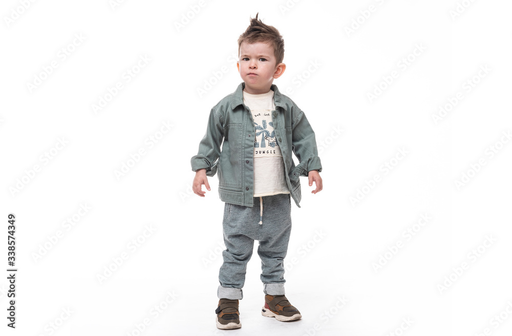 Confused little boy standing on white background. He looks angry. Confused little boy standing on white background. He looks angry.
