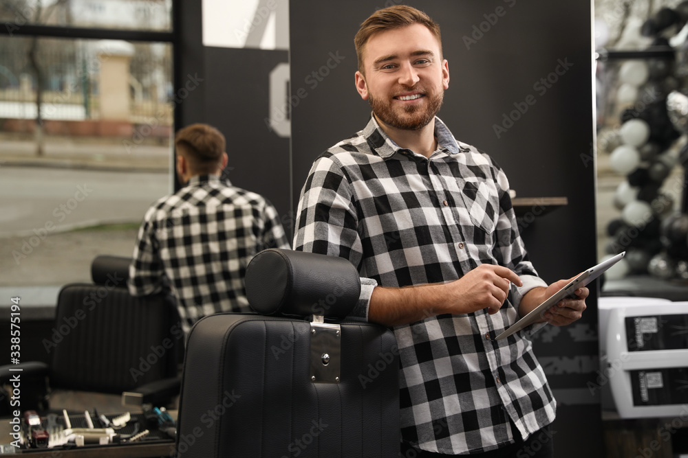 Young business owner with tablet in barber shop Young business owner with tablet in barber shop