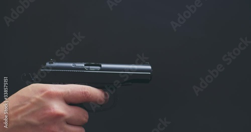 man shutter cocking and shoots with air pistol on black background the gun ran out of ammunition