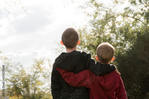 Konstfotografi Niños de espalda abrazados mayor y menor en la naturaleza