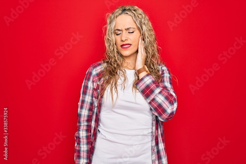 Young beautiful blonde woman wearing casual shirt standing over isolated red background touching mouth with hand with painful expression because of toothache or dental illness on teeth. Dentist