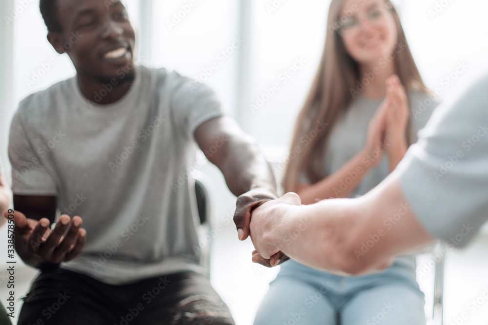 close up. smiling guy shaking hands with his friend close up. smiling guy shaking hands with his friend