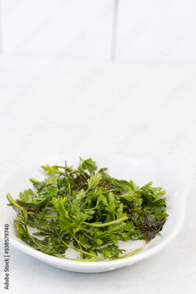 Parsley leafs in the water in the bowl Parsley leafs in the water in the bowl