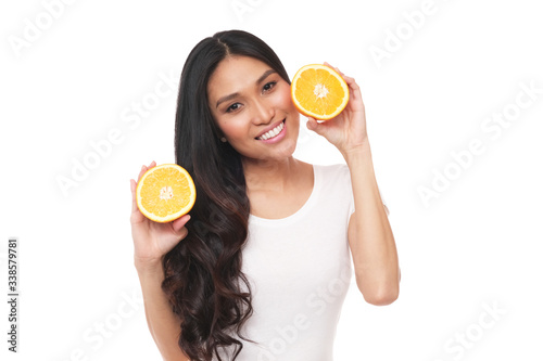 Beautiful asian model posing with citrus as her keys to clean, vital and glowing face. 