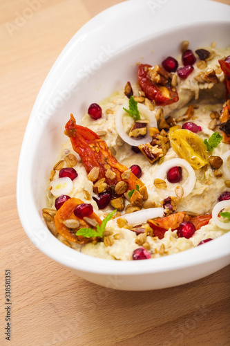Organic plant based hummus with granola dried tomatoes toppings. Perfect for vegan gluten free. Freshly homemade for takeaway and delivery. Healthy food photography.