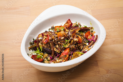 Delicious healthy salad with eggplant and dried tomatoes toppings. For healthy living. Perfect for takeaway and delivery. Vegan food photography.