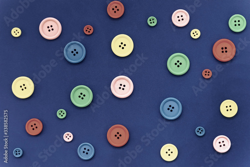 Mix of multicolored buttons, different sizes, top view, flat lay background