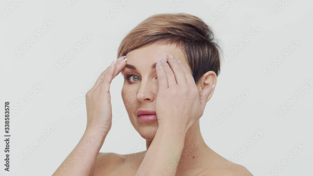 Close-up of middle aged mature woman over white bacjground. Portrait of mature lady. Plastic surgery, beauty injections and cosmetology. Close-up of middle aged mature woman over white bacjground. Portrait of mature lady. Plastic surgery, beauty injections and cosmetology.