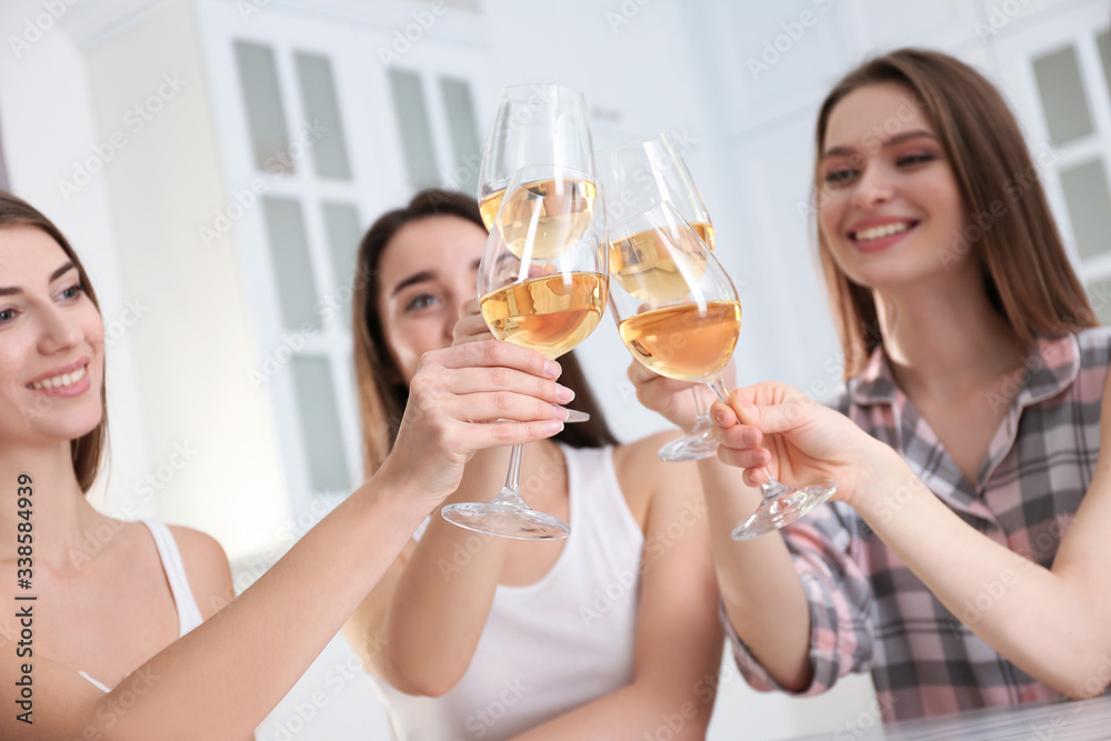 Beautiful young ladies toasting at home, focus on hands with glasses. Woman's Day Beautiful young ladies toasting at home, focus on hands with glasses. Woman's Day