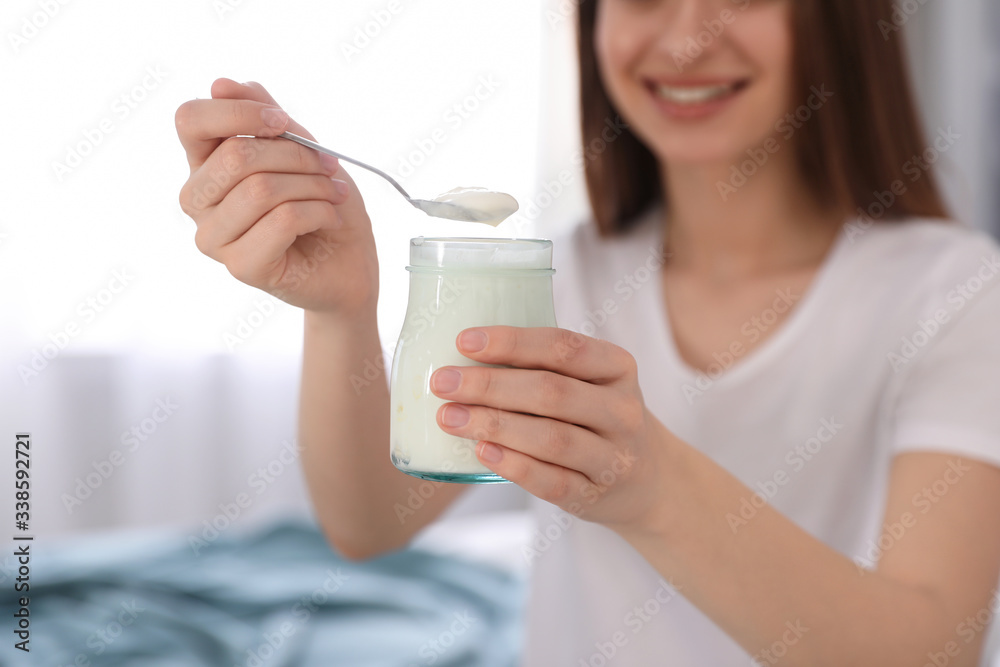 Young attractive woman with tasty yogurt indoors, closeup Young attractive woman with tasty yogurt indoors, closeup