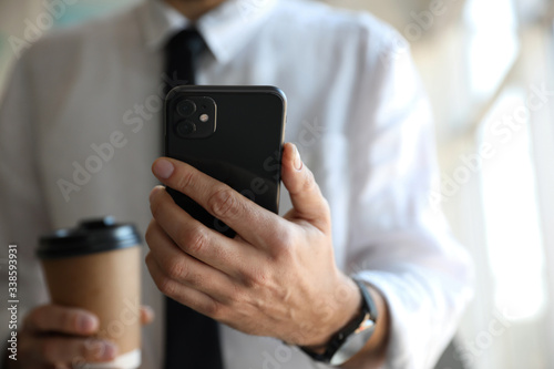 MYKOLAIV, UKRAINE - MARCH 16, 2020: Man holding iPhone 11 Black indoors, closeup