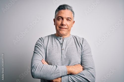 Middle age handsome grey-haired man wearing casual t-shirt over white background happy face smiling with crossed arms looking at the camera. Positive person.