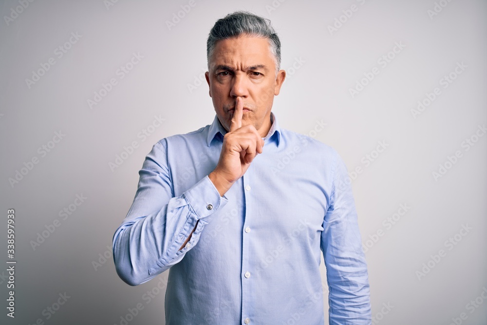 Middle age handsome grey-haired business man wearing elegant shirt over white background asking to be quiet with finger on lips. Silence and secret concept. Middle age handsome grey-haired business man wearing elegant shirt over white background asking to be quiet with finger on lips. Silence and secret concept.