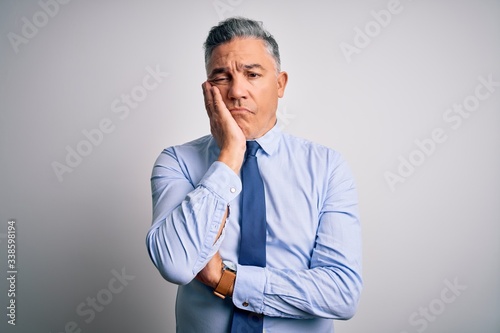 Middle age handsome grey-haired business man wearing elegant shirt and tie thinking looking tired and bored with depression problems with crossed arms.