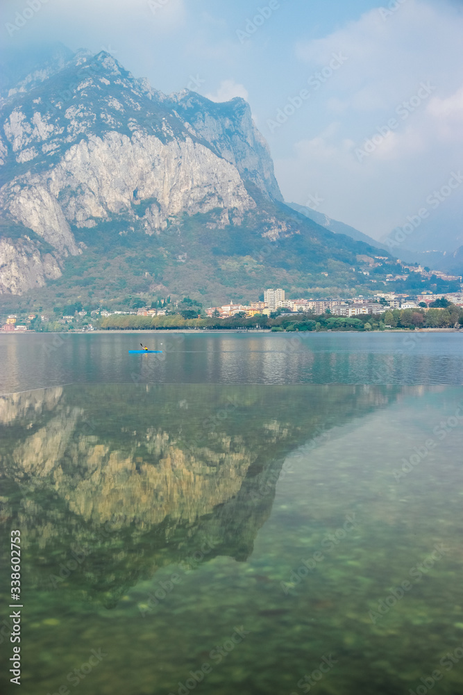 San Martino mountain and Bergamo Alps reflect in the water of Lake Como near the village of Lecco, Lombardy, Northern Italy