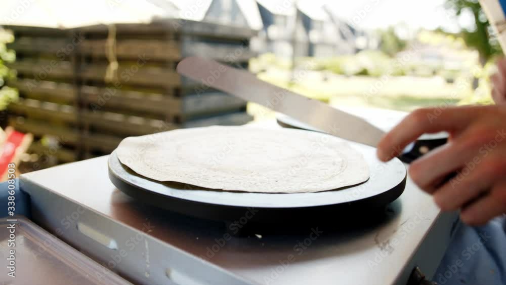 Close up of Person Baking crepe On Pancake Maker and turning in slow motion Close up of Person Baking crepe On Pancake Maker and turning in slow motion