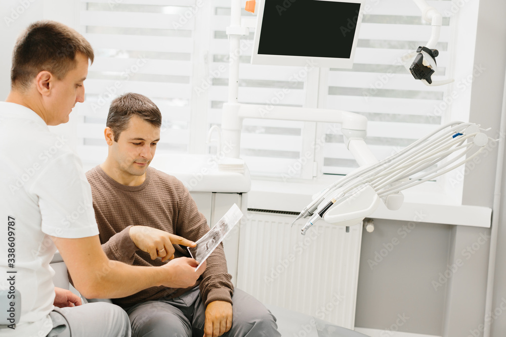 Fototapeta premium Dentist shows a patient x-ray of teeth