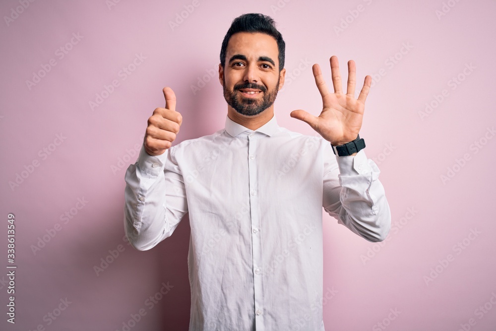 Young handsome man with beard wearing casual shirt standing over pink background showing and pointing up with fingers number six while smiling confident and happy. Young handsome man with beard wearing casual shirt standing over pink background showing and pointing up with fingers number six while smiling confident and happy.