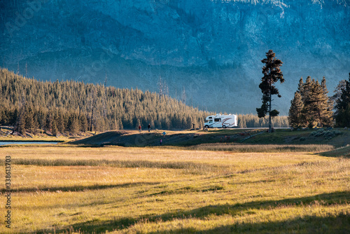 RV parked in an open meadow Yellowstone National Park, Wyoming. Family enjoying summer vacation while traveling in RV