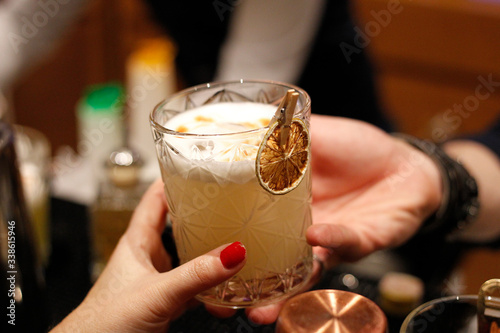 фотографія bartman serving a citrus cocktail in a client's hand