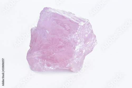 A close up image of a raw rose quartz crystal. 