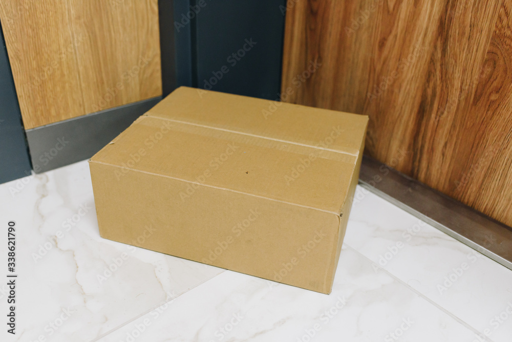 Box delivered via contactless delivery on doormat in front of front door, parcel ordered online during global coronavirus covid-19 infection pandemic as digital transformation changes e-commerce Box delivered via contactless delivery on doormat in front of front door, parcel ordered online during global coronavirus covid-19 infection pandemic as digital transformation changes e-commerce
