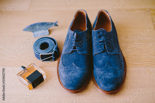 man's shoes with belt and perfume
