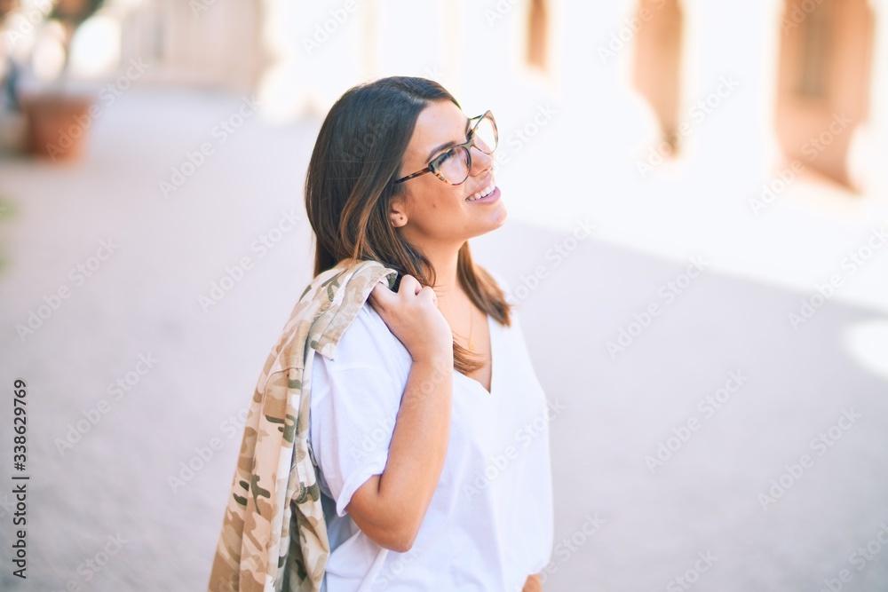 Young beautiful woman smiling happy and confident. Standing with smile on face at the town street Young beautiful woman smiling happy and confident. Standing with smile on face at the town street