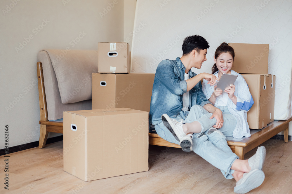 Young Asian couple using tablet computers in new home Young Asian couple using tablet computers in new home