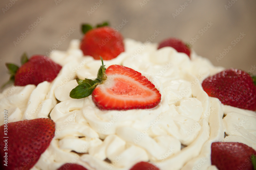 Two layer cake with strawberries and whipped cream on a glass cake platter Two layer cake with strawberries and whipped cream on a glass cake platter