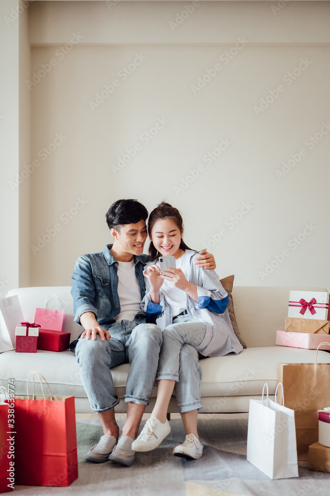 Young Asian couple at home using a smartphone