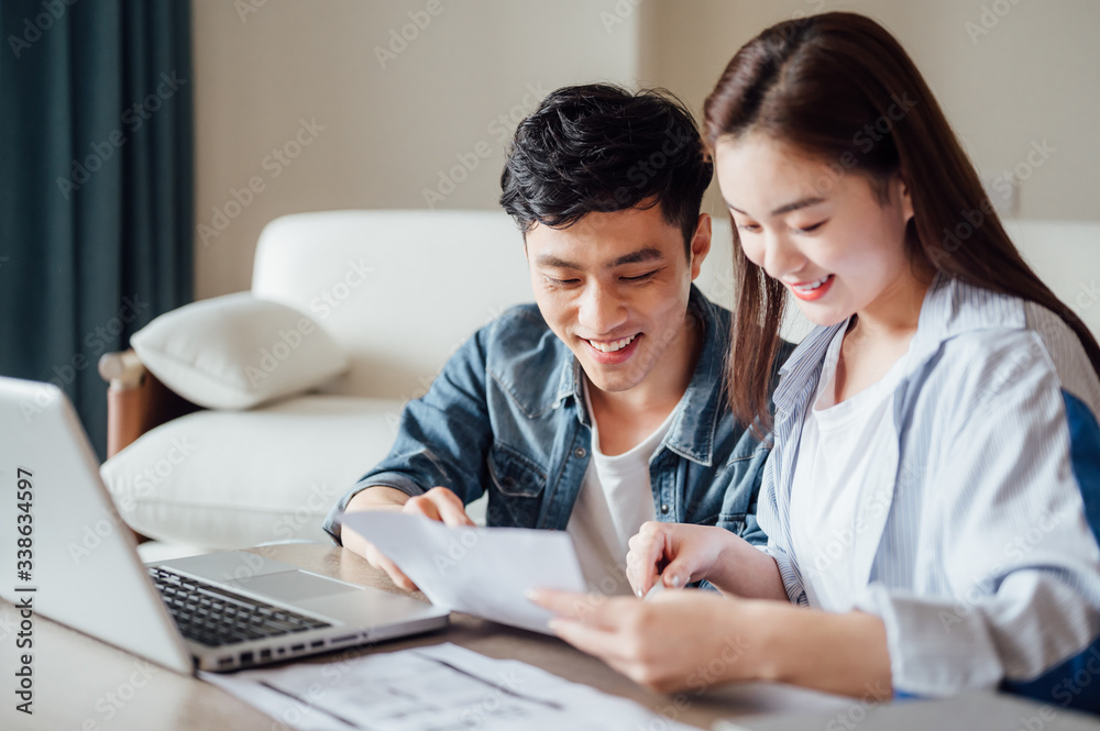 Young Asian couple at home using computer Young Asian couple at home using computer